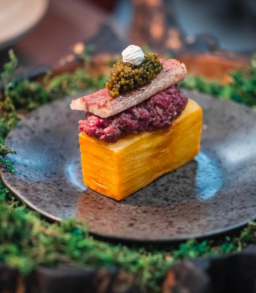 Picho de milhojas con steak tartar, anguila ahumada, caviar y crema agria.